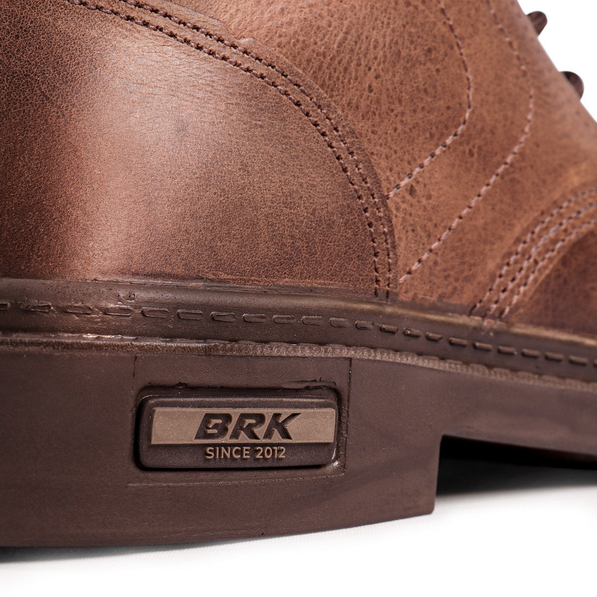 Close-up de sapato masculino marrom em couro com detalhe da marca BRK desde 2012 na sola